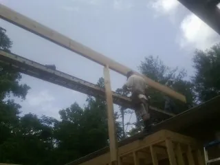 Carpenter setting a ridge beam over a new addition frame — Ice Dam Removal by Roofing Brothers in Manns Choice