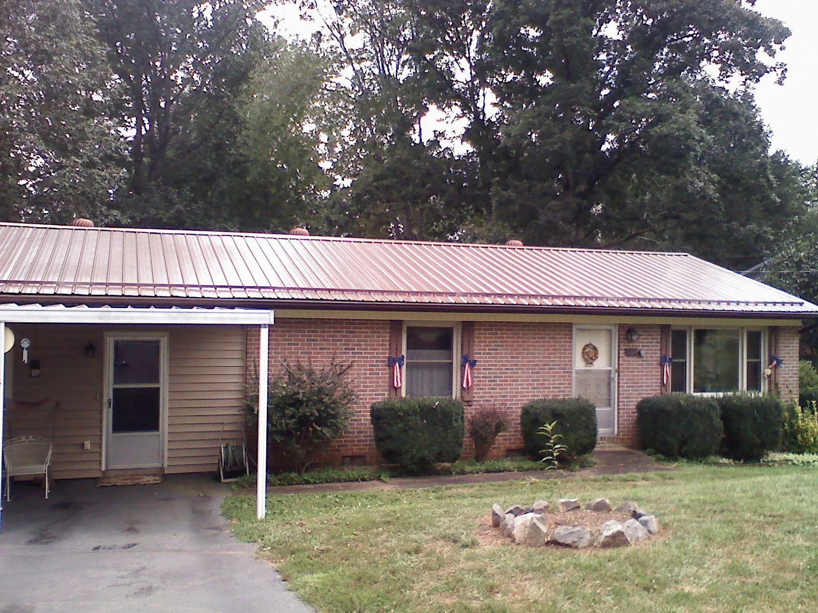 Bronze metal roof and carport on a brick ranch home — Roof Repair work by our crew in Manns Choice