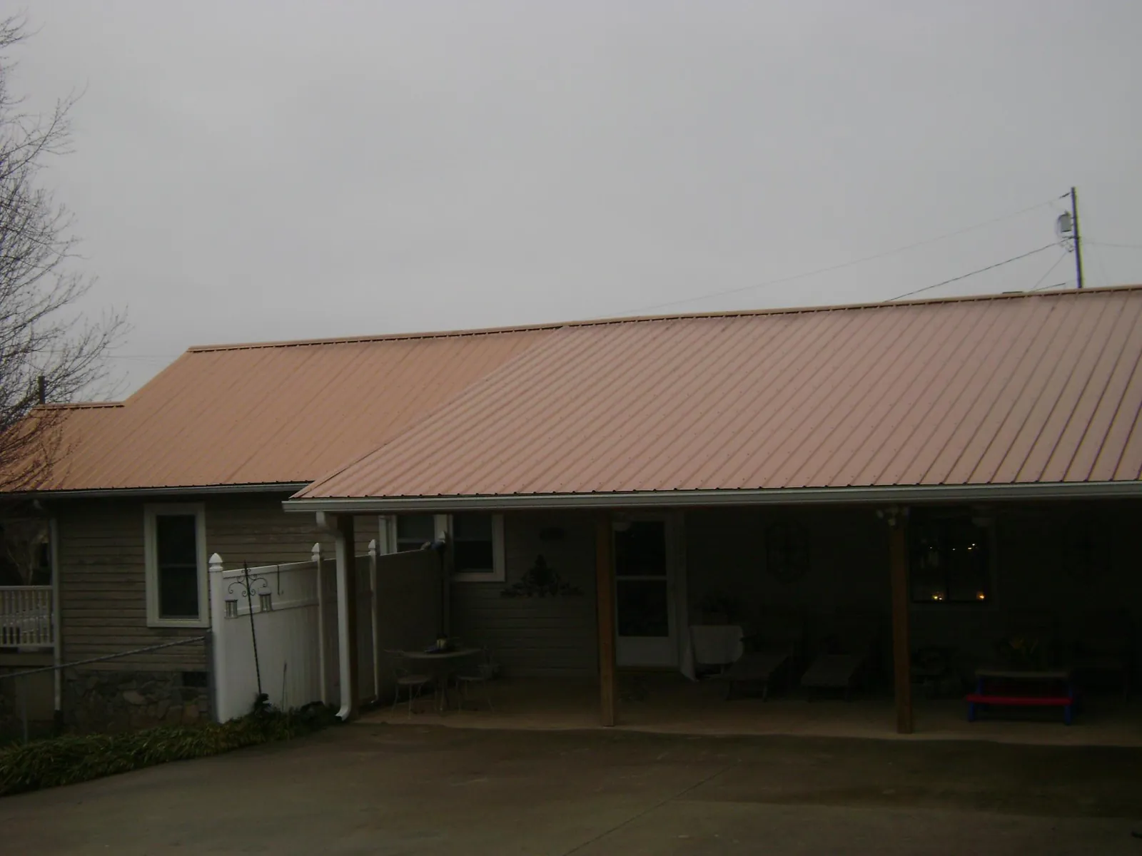 Copper toned metal roof over a wide covered patio in Manns Choice